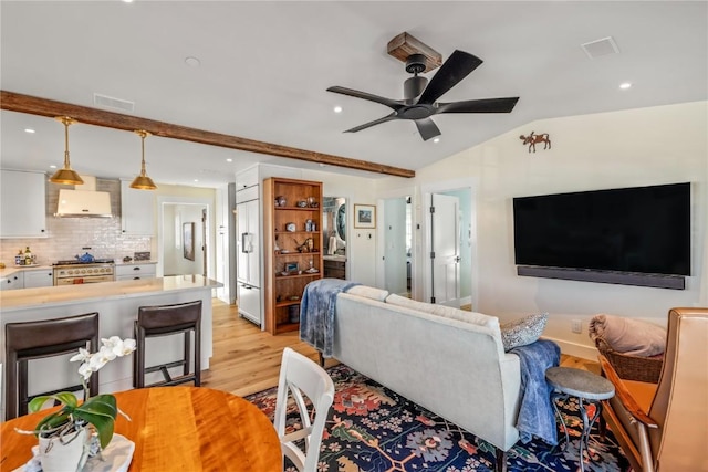 living room featuring ceiling fan, vaulted ceiling with beams, and light wood-type flooring