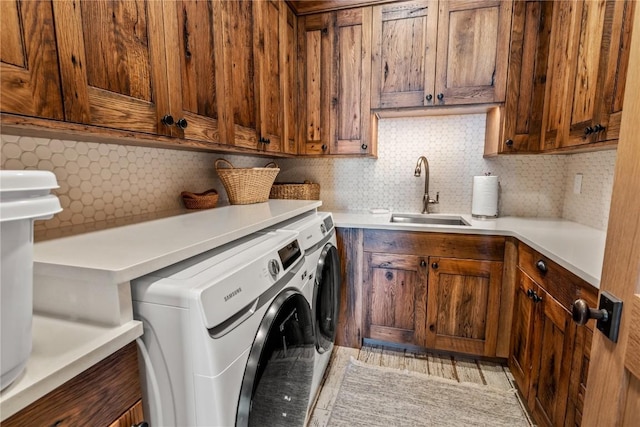 laundry area with washer and dryer, sink, and cabinets