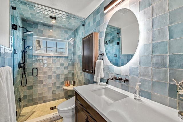 bathroom with tile walls, an enclosed shower, vanity, decorative backsplash, and toilet