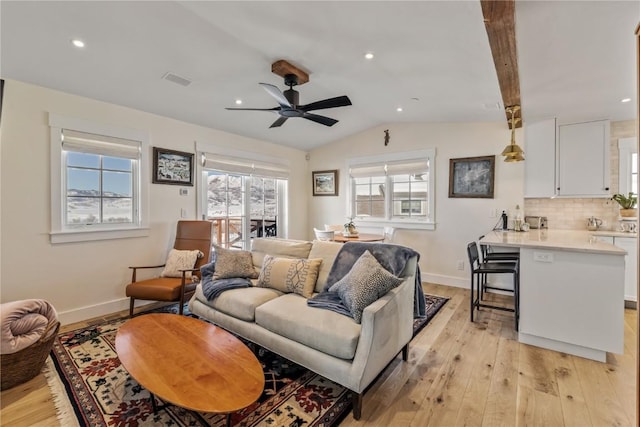 living room with ceiling fan, lofted ceiling, and light wood-type flooring