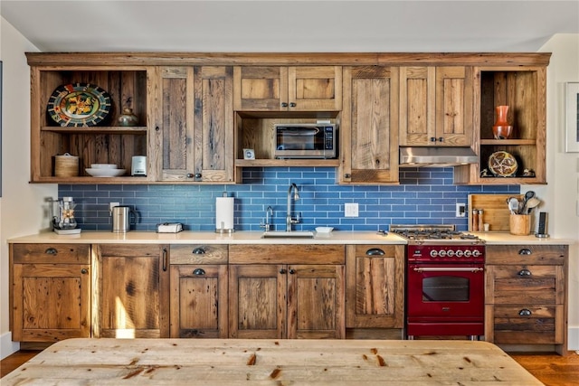 kitchen with tasteful backsplash, stainless steel microwave, range, and sink