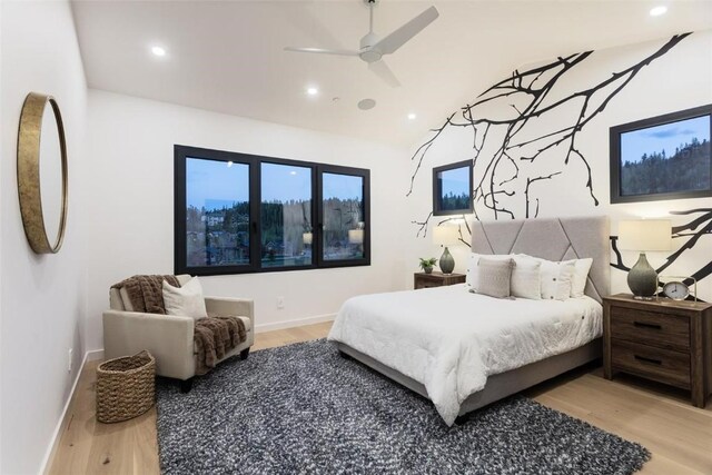 bedroom with light hardwood / wood-style flooring, ceiling fan, and lofted ceiling