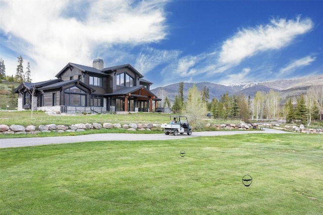 view of property's community featuring a mountain view and a yard