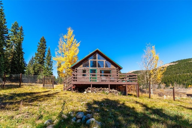 rear view of house with a lawn and a deck