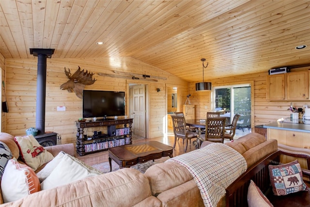 living room featuring a wood stove, vaulted ceiling, wood ceiling, and wood walls