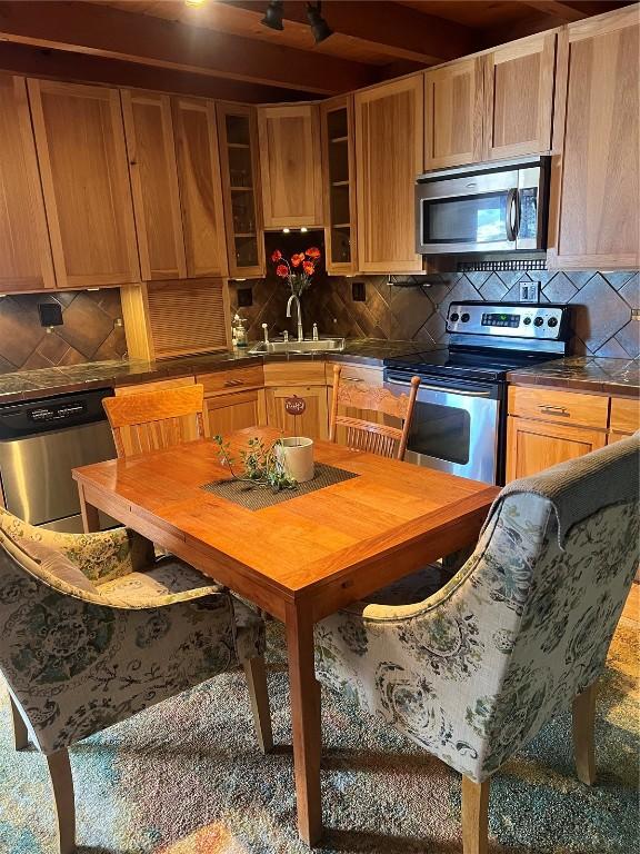 kitchen with stainless steel appliances, sink, and backsplash