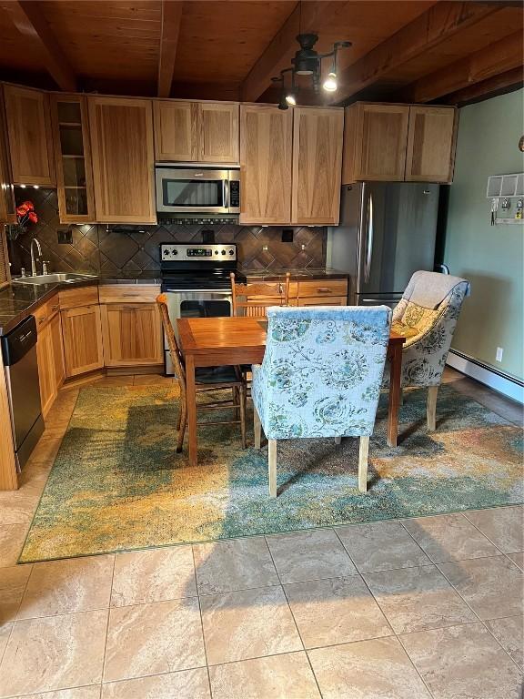 kitchen with stainless steel appliances, tasteful backsplash, a baseboard heating unit, and beam ceiling