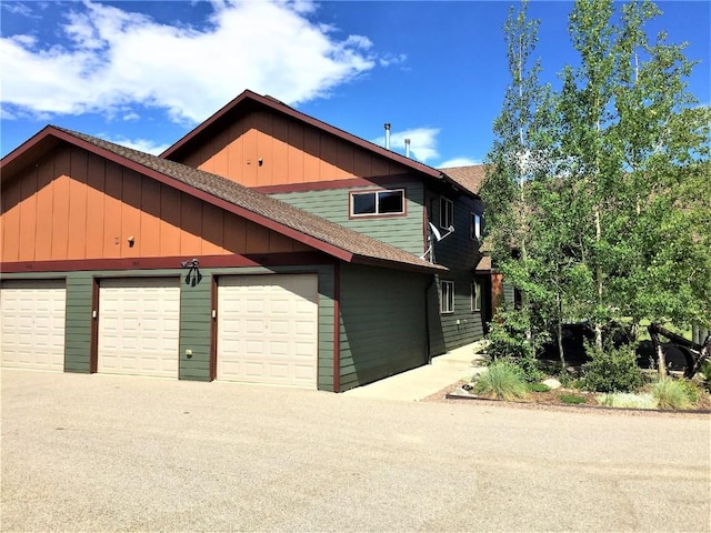 view of front of home featuring driveway, roof with shingles, and an attached garage