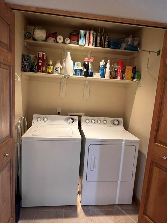 laundry area featuring laundry area, washing machine and clothes dryer, and light tile patterned floors