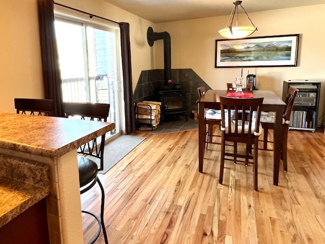 dining room featuring light wood-style floors and a wood stove