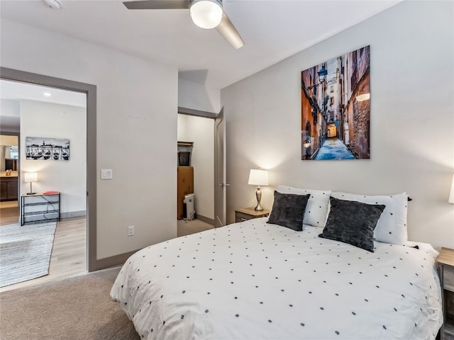 carpeted bedroom with ceiling fan and ensuite bath