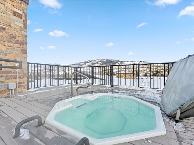 wooden terrace featuring a water view and a jacuzzi