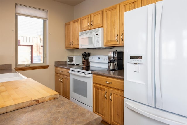 kitchen featuring white appliances, dark countertops, and a toaster