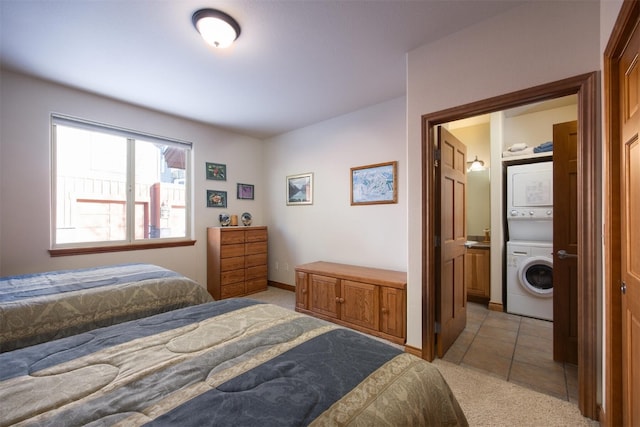 carpeted bedroom featuring ensuite bath and stacked washer and dryer