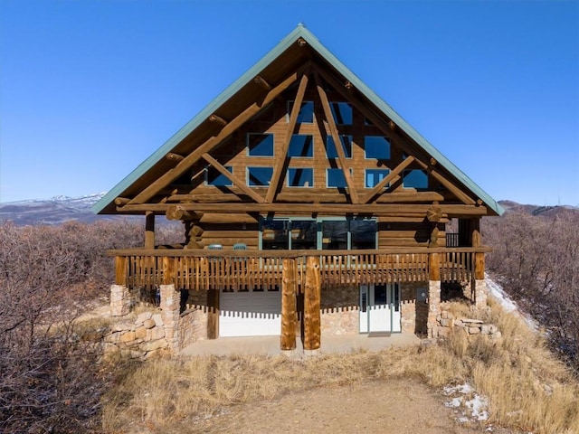 back of property featuring a deck with mountain view and log exterior