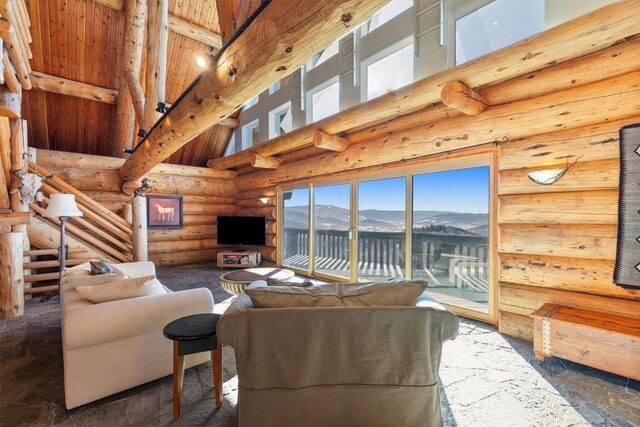 living room featuring stairs, high vaulted ceiling, and beam ceiling