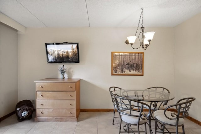 dining area with light tile patterned floors, a textured ceiling, and an inviting chandelier