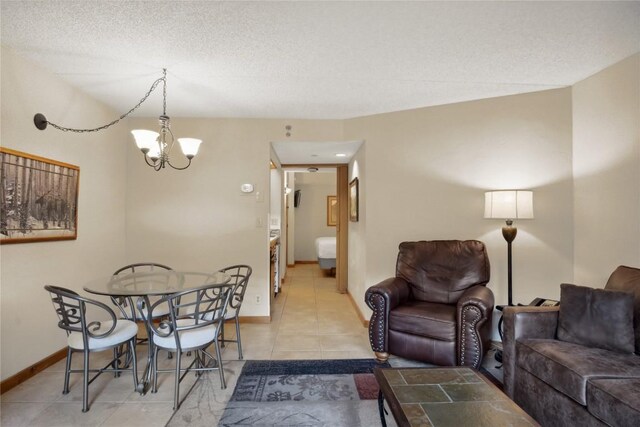 dining space with a notable chandelier, light tile patterned floors, and a textured ceiling