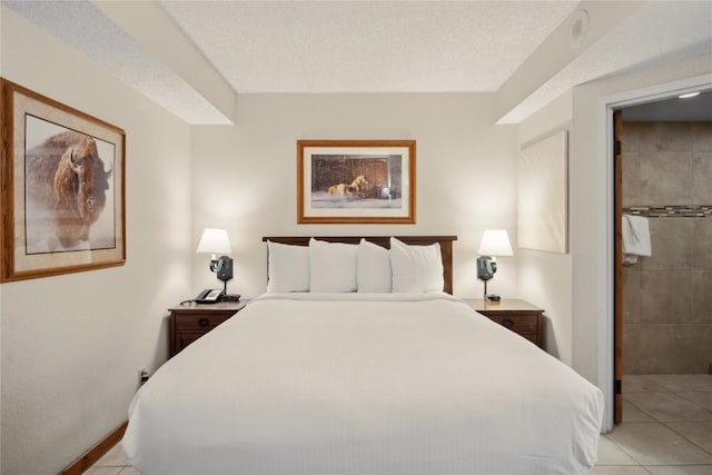 bedroom featuring light tile patterned floors, a textured ceiling, and ensuite bath