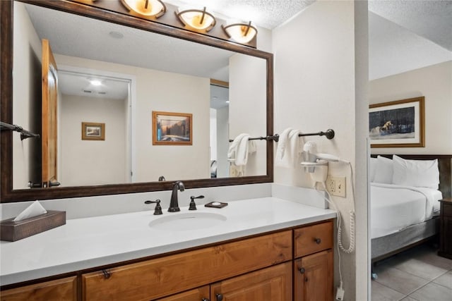 bathroom featuring tile patterned floors, vanity, and a textured ceiling