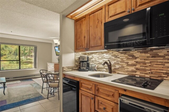 kitchen with black appliances, sink, tasteful backsplash, light tile patterned flooring, and a baseboard radiator