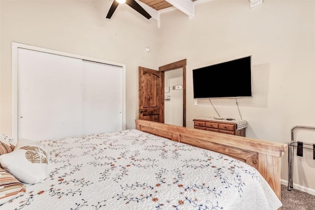 bedroom with wooden ceiling, ceiling fan, beamed ceiling, carpet floors, and a closet