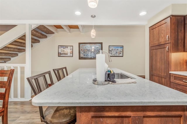 dining room with beamed ceiling and light wood-type flooring