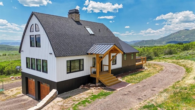 44255 Diamondback Way, Steamboat Springs, CO 80487 - view of front of property with driveway, a mountain view, a standing seam roof, and an attached garage