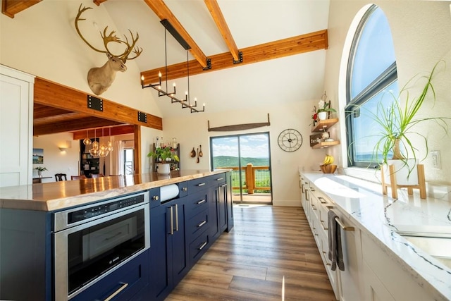 44255 Diamondback Way, Steamboat Springs, CO 80487 - kitchen featuring blue cabinetry, a chandelier, beam ceiling, high vaulted ceiling, and wood finished floors