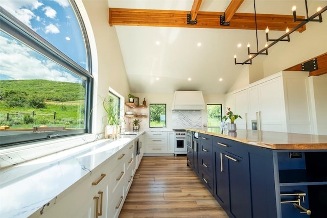 44255 Diamondback Way, Steamboat Springs, CO 80487 - kitchen with custom exhaust hood, open shelves, white cabinetry, beamed ceiling, and blue cabinetry