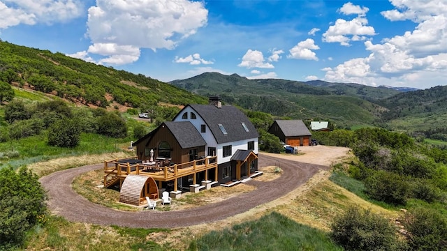 44255 Diamondback Way, Steamboat Springs, CO 80487 - rear view of house with driveway, a deck with mountain view, and a chimney