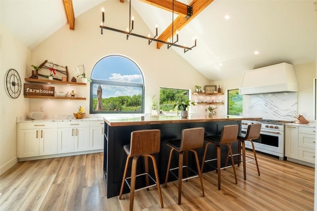 44255 Diamondback Way, Steamboat Springs, CO 80487 - kitchen featuring open shelves, high end white range, premium range hood, white cabinets, and a center island