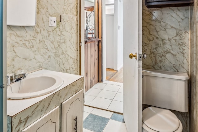 bathroom with toilet, vanity, and tile patterned floors