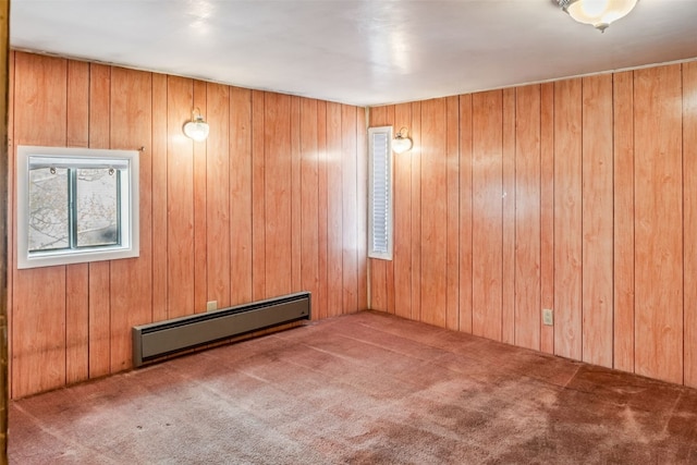carpeted spare room with a baseboard radiator and wooden walls
