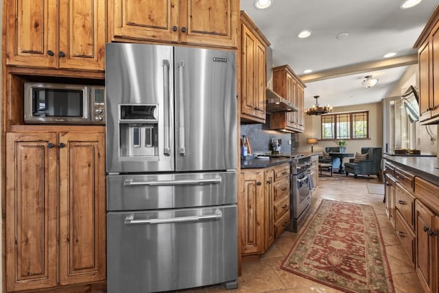 40924 Purple Sage St, Steamboat Springs, CO 80487 - kitchen with high end appliances, dark countertops, brown cabinets, recessed lighting, and a chandelier