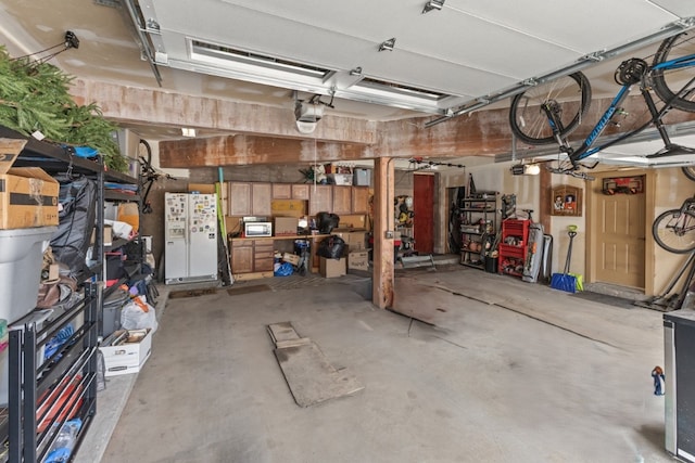 40924 Purple Sage St, Steamboat Springs, CO 80487 - garage featuring white refrigerator with ice dispenser and a garage door opener