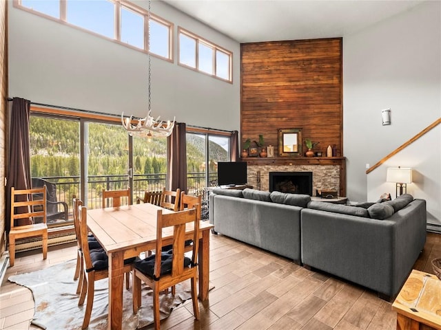 22320 US Highway 6 Unit 1761, Keystone, CO 80435 - dining space with a high ceiling, a chandelier, healthy amount of natural light, a stone fireplace, and light wood-type flooring