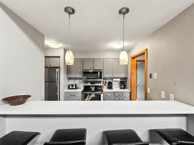 22320 US Highway 6 Unit 1761, Keystone, CO 80435 - kitchen featuring stainless steel appliances, gray cabinets, decorative backsplash, a peninsula, and hanging light fixtures