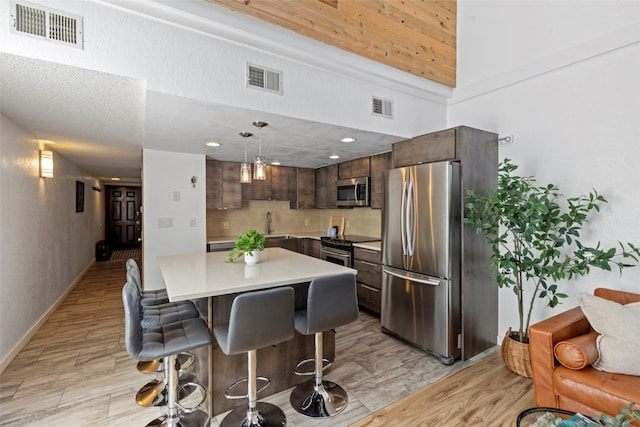 kitchen featuring visible vents, appliances with stainless steel finishes, and a breakfast bar area