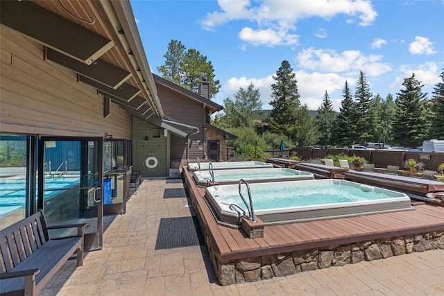 view of swimming pool with a patio area, a fenced in pool, and an outdoor hot tub