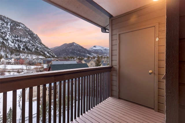 snow covered back of property with a mountain view and a residential view