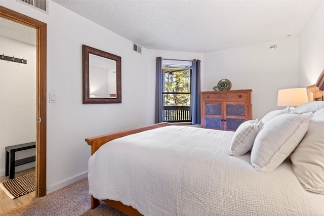 bedroom featuring a textured ceiling, visible vents, and baseboards