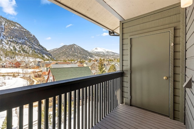 snow covered back of property featuring a mountain view and a residential view