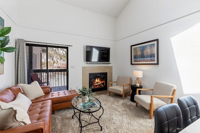 living room featuring high vaulted ceiling and a tile fireplace