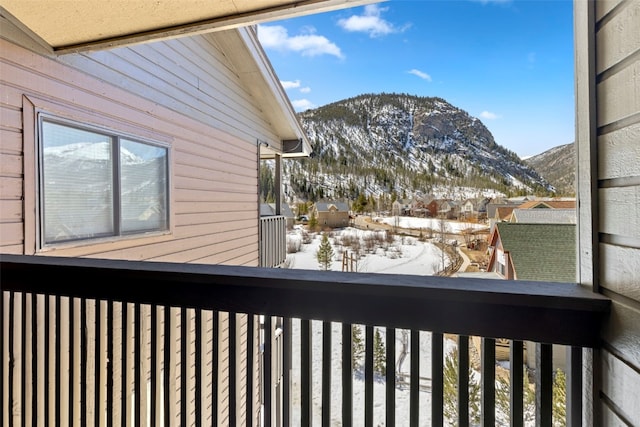 snow covered back of property with a mountain view