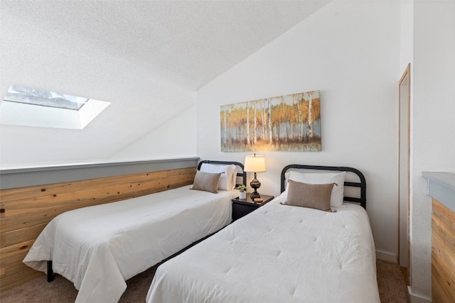 carpeted bedroom with lofted ceiling with skylight and a textured ceiling