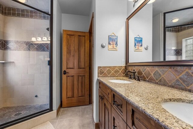 2137 Overlook Ln Unit 104, Steamboat Springs, CO 80487 - full bathroom featuring a stall shower, double vanity, tile patterned flooring, and decorative backsplash