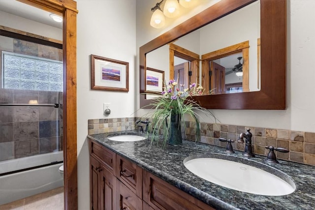 2137 Overlook Ln Unit 104, Steamboat Springs, CO 80487 - full bathroom featuring double vanity, toilet, shower / bath combination with glass door, and tasteful backsplash