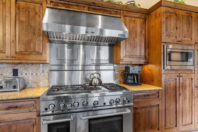 2137 Overlook Ln Unit 104, Steamboat Springs, CO 80487 - kitchen featuring stainless steel appliances, brown cabinets, and decorative backsplash