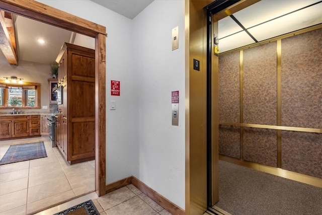 2137 Overlook Ln Unit 104, Steamboat Springs, CO 80487 - hallway featuring elevator, light tile patterned floors, a sink, and baseboards